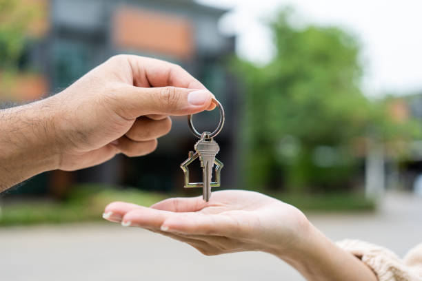 Handing over house keys to a first home buyer outside an Australian home
