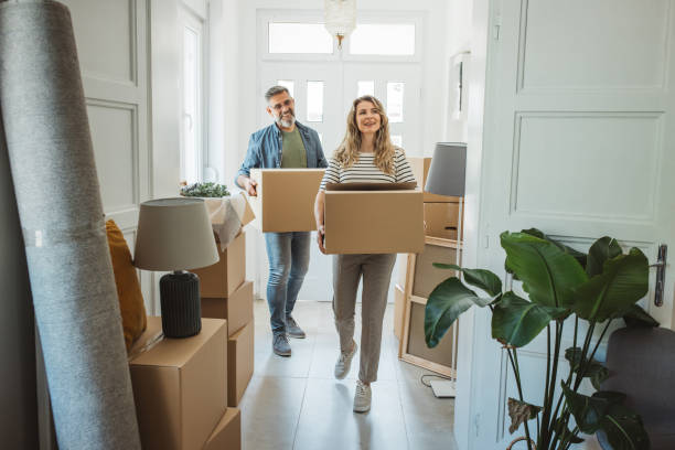 Couple moving into a new home carrying boxes, representing connecting energy and gas when moving house